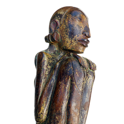 Bali female anamist figure of slender form and seated in a typical hunkerred position